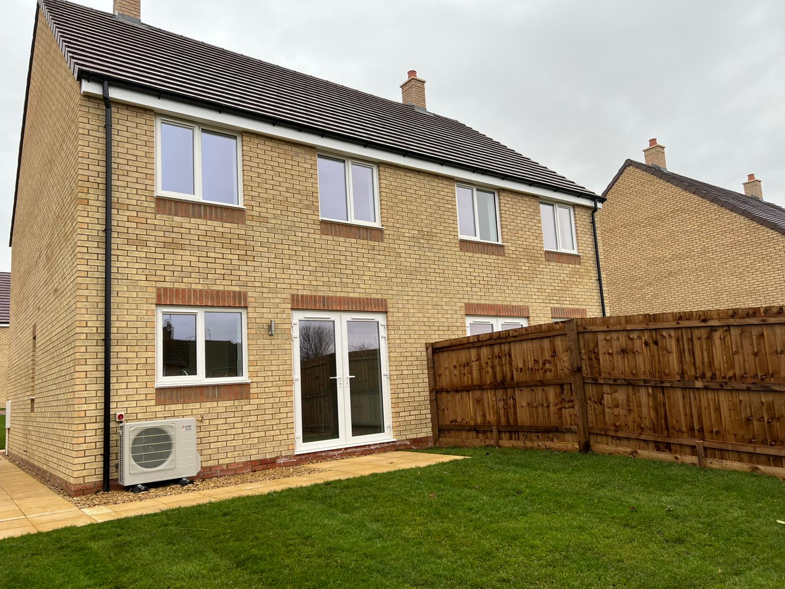 Rear of two-bed for rent, showing air source heat pump